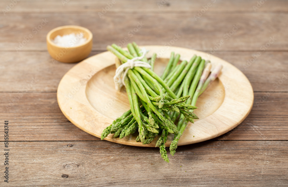 Asparagus is green and straight vegetable. Fresh, green asparagus is crispy for cook on wood table with salt Asparagus is green and straight vegetable. Fresh, green asparagus is crispy for cook on wood table with salt