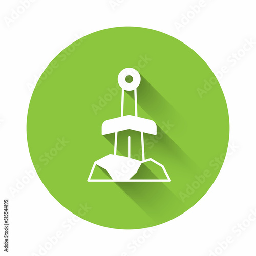 White Sword in the stone icon isolated with long shadow background. Excalibur the sword in the stone from the Arthurian legends. Green circle button. Vector