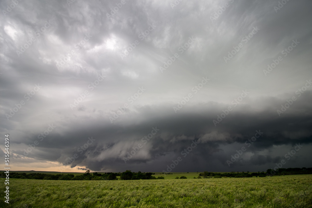 A severe thunderstorm with a shelf cloud over a green field in Kansas. A severe thunderstorm with a shelf cloud over a green field in Kansas.