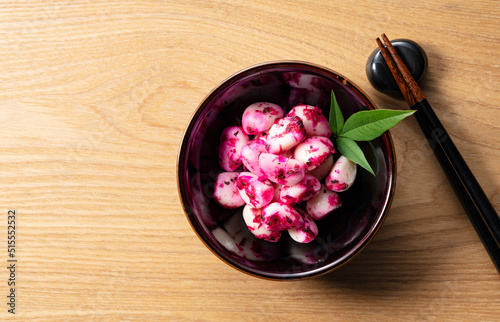 Pickled shiso bonito garlic on a plate placed against a wooden background. photo