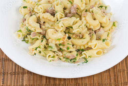 Prepared pasta with chopped boiled meat, fried onion and dill photo