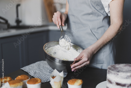 Young lovely woman pastry chef preparing cake cream at home