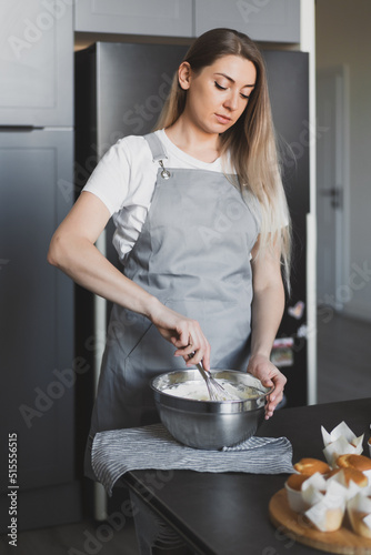 Young lovely woman pastry chef preparing cake cream at home