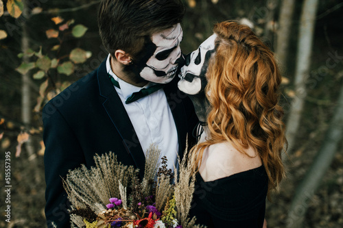 A couple in love is sitting hugging against the backdrop of mountains celebrating Halloween in costu photo