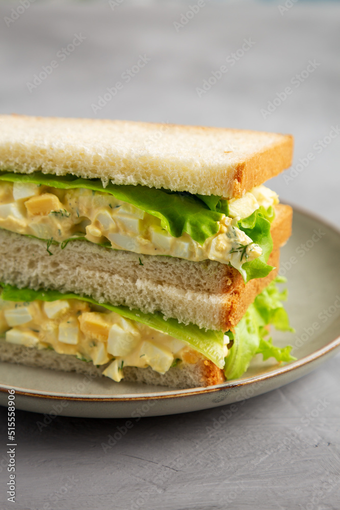 Homemade Egg Salad Sandwich with Lettuce on a Plate, side view. Homemade Egg Salad Sandwich with Lettuce on a Plate, side view.