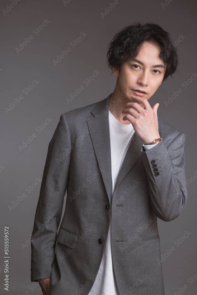 ジャケットを着た若い男性のポートレート/スタジオ撮影グレー背景