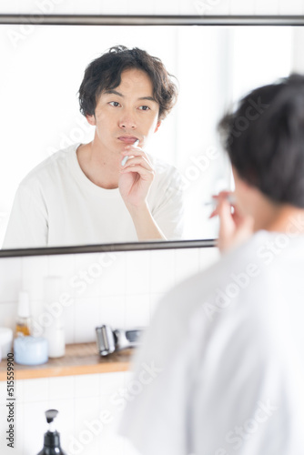 鏡を見ながら歯磨きをする男性