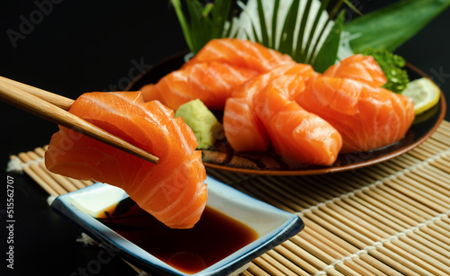 Sashimi, Salmon, Japanese food chopsticks and wasabi on the wood table. photo