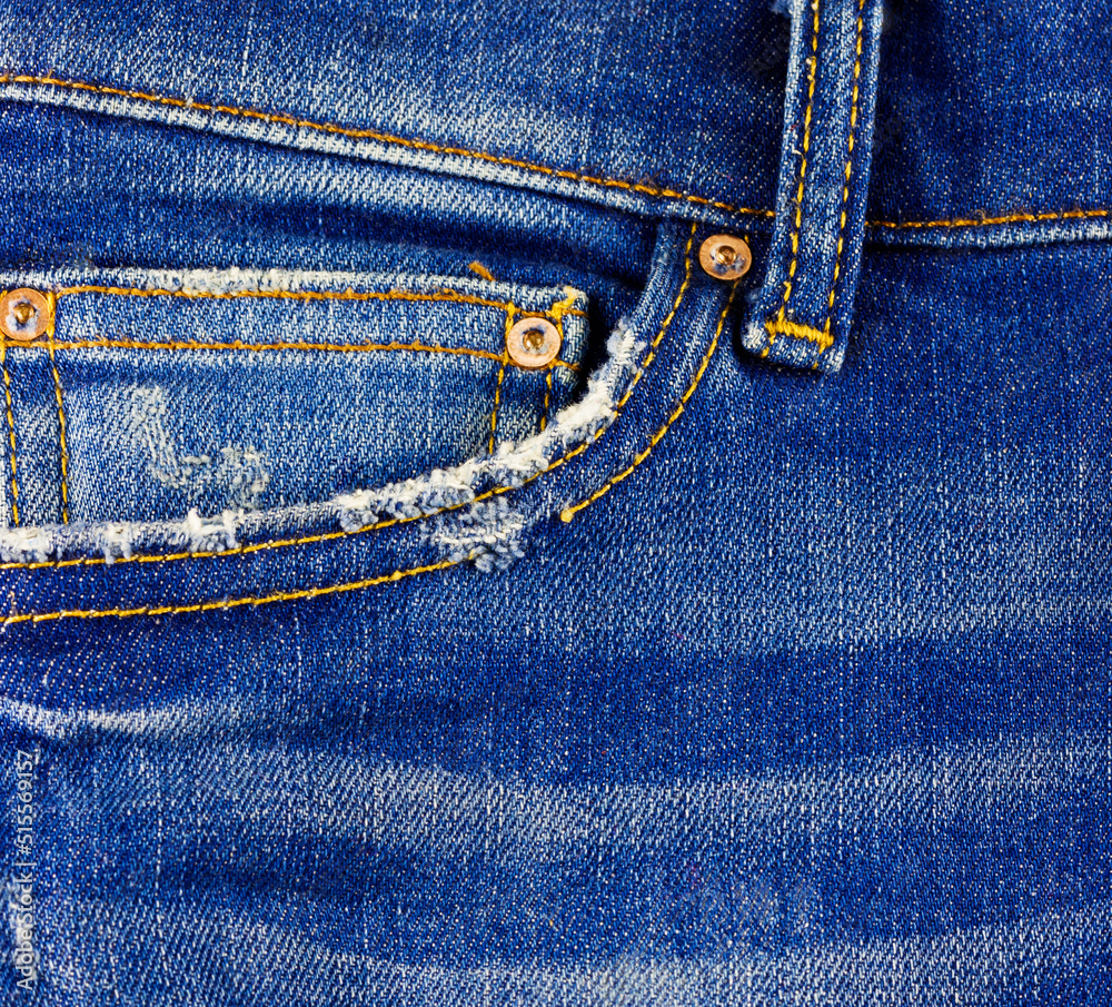 Jeans with frayed pockets and yellow stitching close-up. Jeans with frayed pockets and yellow stitching close-up.