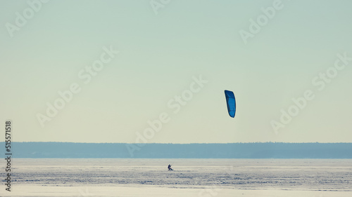 The man doing snowkiting on the icy snow field