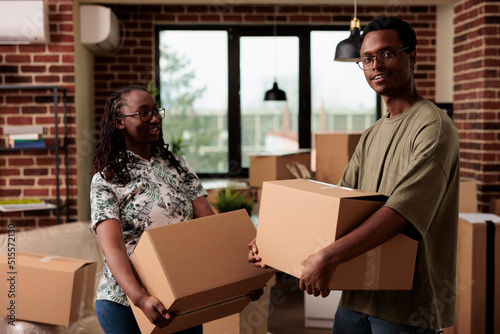 Portrait of african american homeowners feeling happy about moving household, starting new beginning for future family. Enjoying home relocation with furniture, romantic life event.