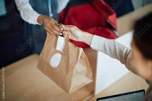Close up of businesswoman receives food delivery in the office.