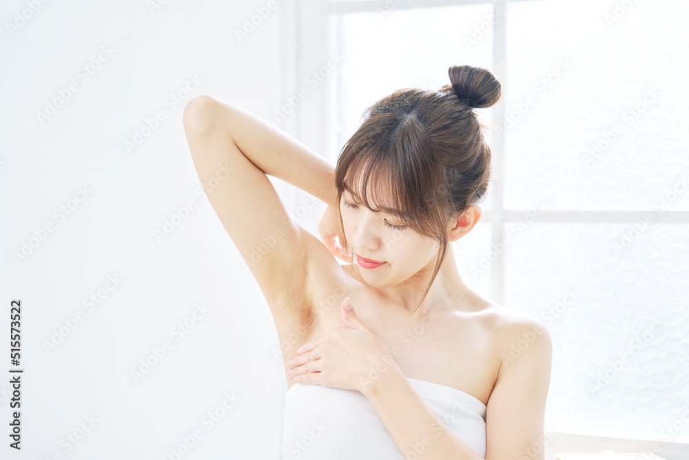 リビングで脇の下をチェックする女性 リビングで脇の下をチェックする女性