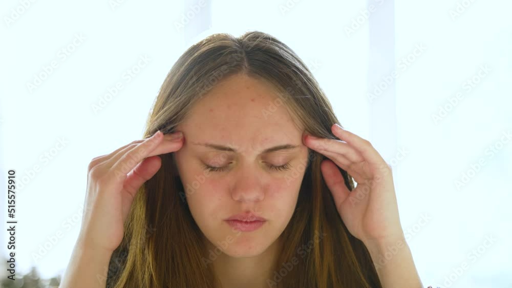Headache.Fatigue and pain on girl face.Brunette upset unhappy child.Portrait of an excited girl with tired eyes.Beautiful young woman rubs her head with her hands.Tired sick eyes.High pressure concept Headache.Fatigue and pain on girl face.Brunette upset unhappy child.Portrait of an excited girl with tired eyes.Beautiful young woman rubs her head with her hands.Tired sick eyes.High pressure concept
