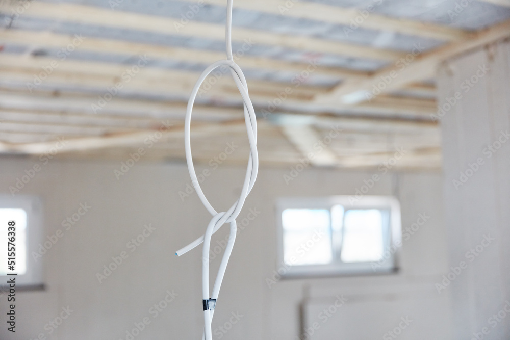 Power cable hangs from the ceiling in the room in the new house Power cable hangs from the ceiling in the room in the new house