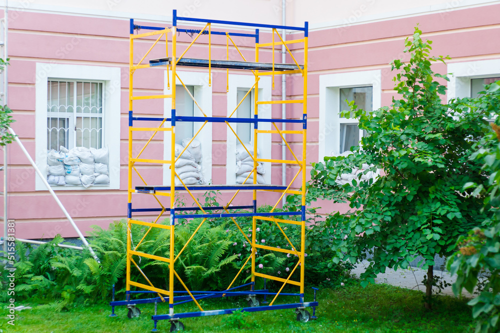 Yellowblue construction scaffolding on the background of a pink