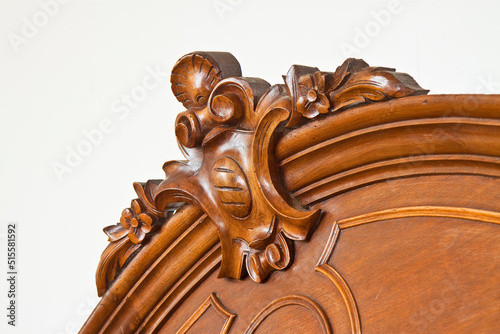 Detail of an old carved italian wooden furniture with floral elements just restored