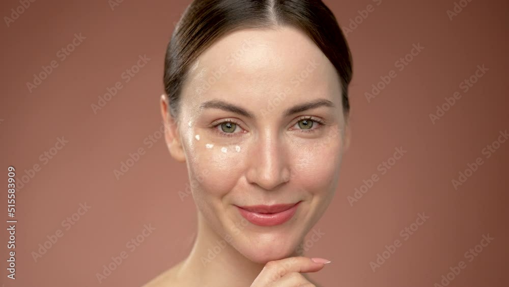 Young woman with cream dots under eye