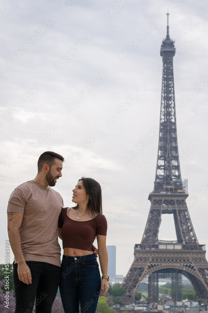 Young couple looking at each other with the eiffel tower in the background