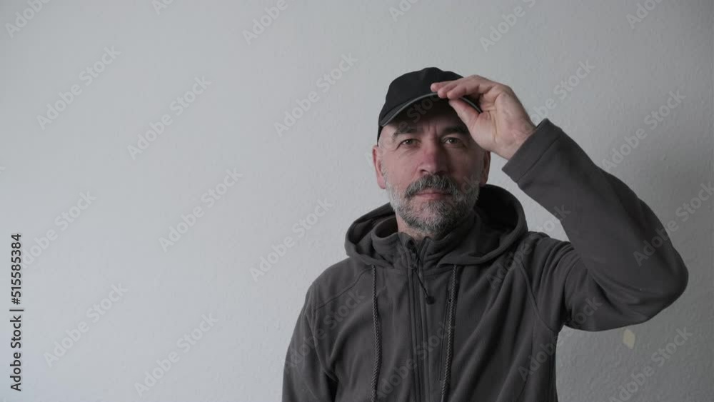 Bearded man in a cap on a white background in the studio looking at the camera Bearded man in a cap on a white background in the studio looking at the camera