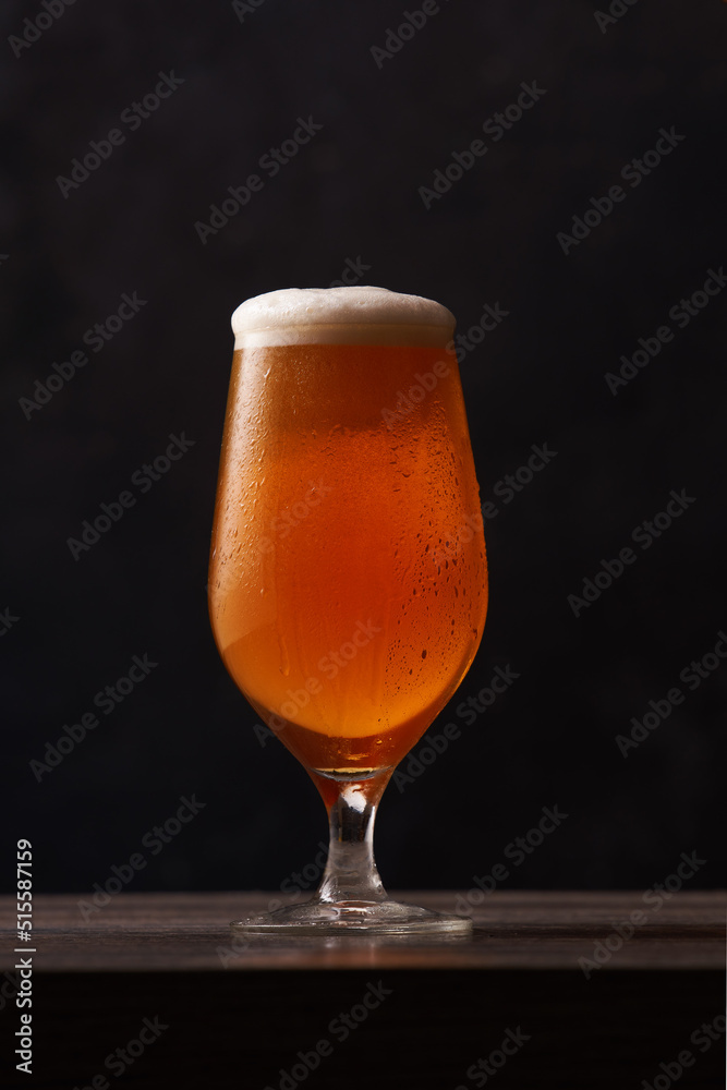 Tulip glass of beer on black background. Tulip glass of beer on black background.