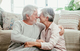 Relaxed caucasian senior couple sitting on the floor at home hugging each other nose to nose looking into each other's eyes