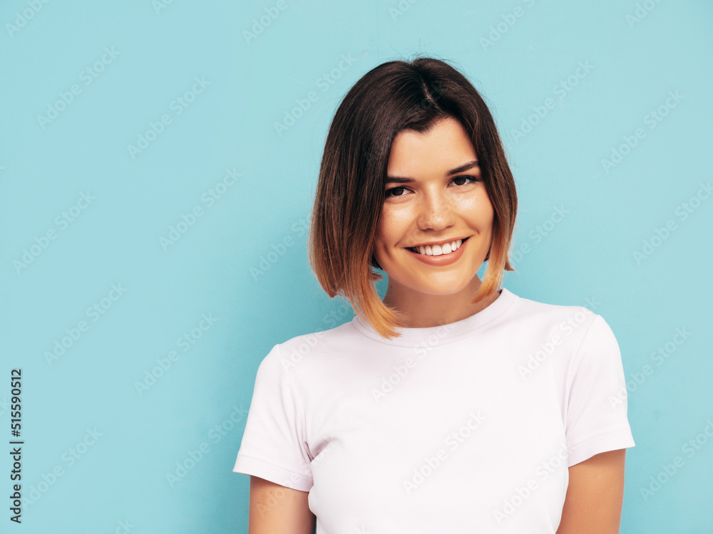 Portrait of young beautiful smiling female in trendy summer clothes. Carefree woman posing near blue wall in studio. Sexy positive model having fun indoors. Cheerful and happy. Isolated Portrait of young beautiful smiling female in trendy summer clothes. Carefree woman posing near blue wall in studio. Sexy positive model having fun indoors. Cheerful and happy. Isolated