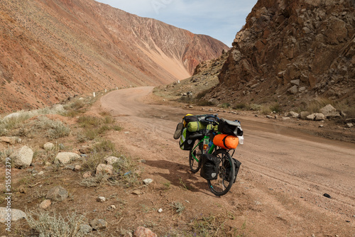 Tourist bike on a mountain road. traveler's bike with bags stand on the Mountain road. Kyrgyzstan