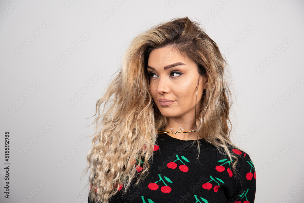 Portrait of a smiling woman standing and looking away isolated over gray background Portrait of a smiling woman standing and looking away isolated over gray background