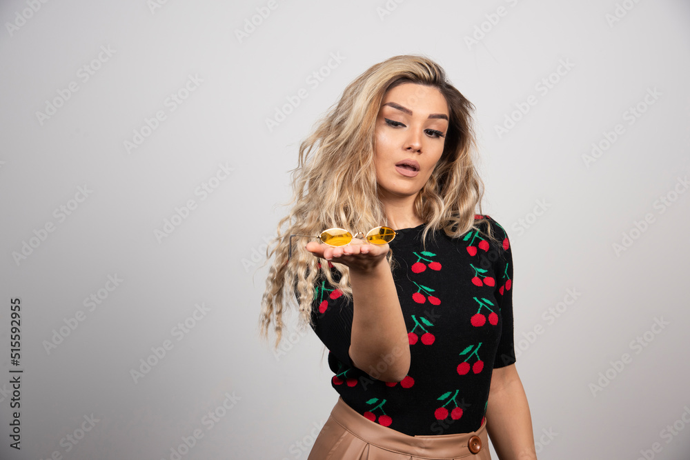 A pretty woman presenting glasses on the hand A pretty woman presenting glasses on the hand