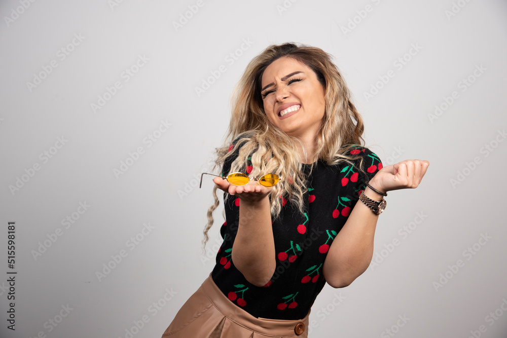 A young woman presenting glasses on the hand A young woman presenting glasses on the hand