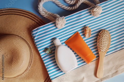 Summer beach bag, travel toiletries set and straw hat. Vacation tour package. Flat lay beauty photography