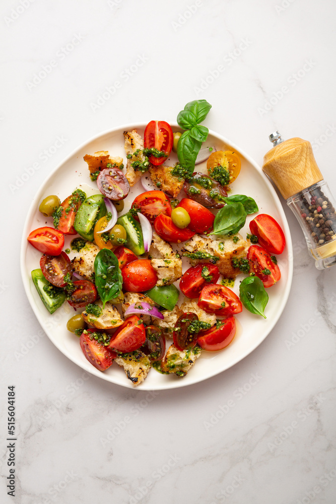 Top view of summer tomatoes croutons salad with pesto