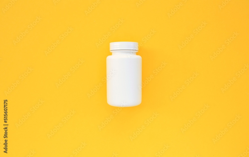 White plastic container for tablets on yellow background with copy space for text. Medicine closed bottle for capsules, pills, drugs. Medical pillbox. Healthcare concept. Mock up, flatlay, close-up White plastic container for tablets on yellow background with copy space for text. Medicine closed bottle for capsules, pills, drugs. Medical pillbox. Healthcare concept. Mock up, flatlay, close-up