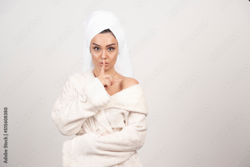 Beautiful young woman in a white bathrobe posing on a white wall Beautiful young woman in a white bathrobe posing on a white wall