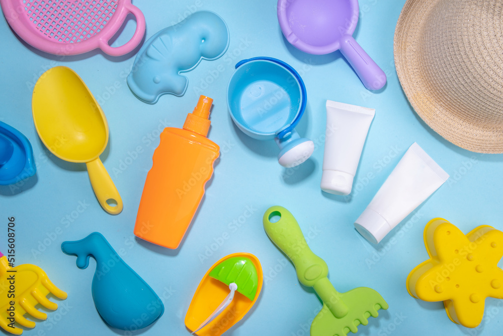 Baby Sunscreen suncare concept. Suntan lotion bottles with kids vacation accessory, sand molds, panama hat, on light blue background copy space Baby Sunscreen suncare concept. Suntan lotion bottles with kids vacation accessory, sand molds, panama hat, on light blue background copy space