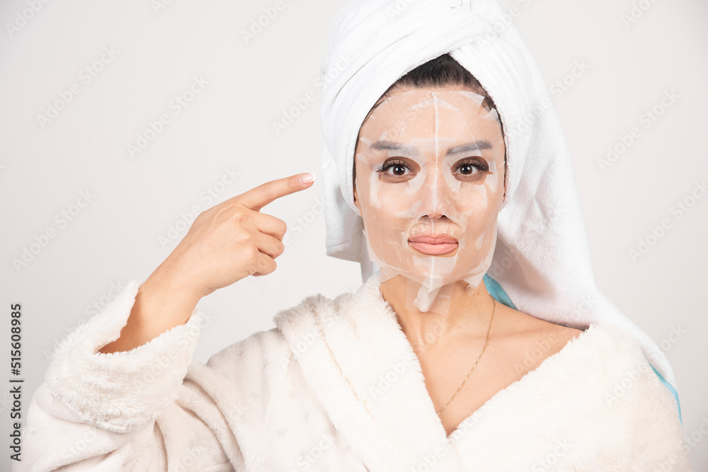 Woman wearing bathrobe and towel with facemask Woman wearing bathrobe and towel with facemask