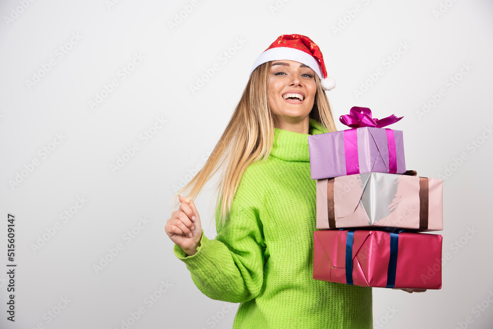Young smiling woman holding in hands festive Christmas presents Young smiling woman holding in hands festive Christmas presents