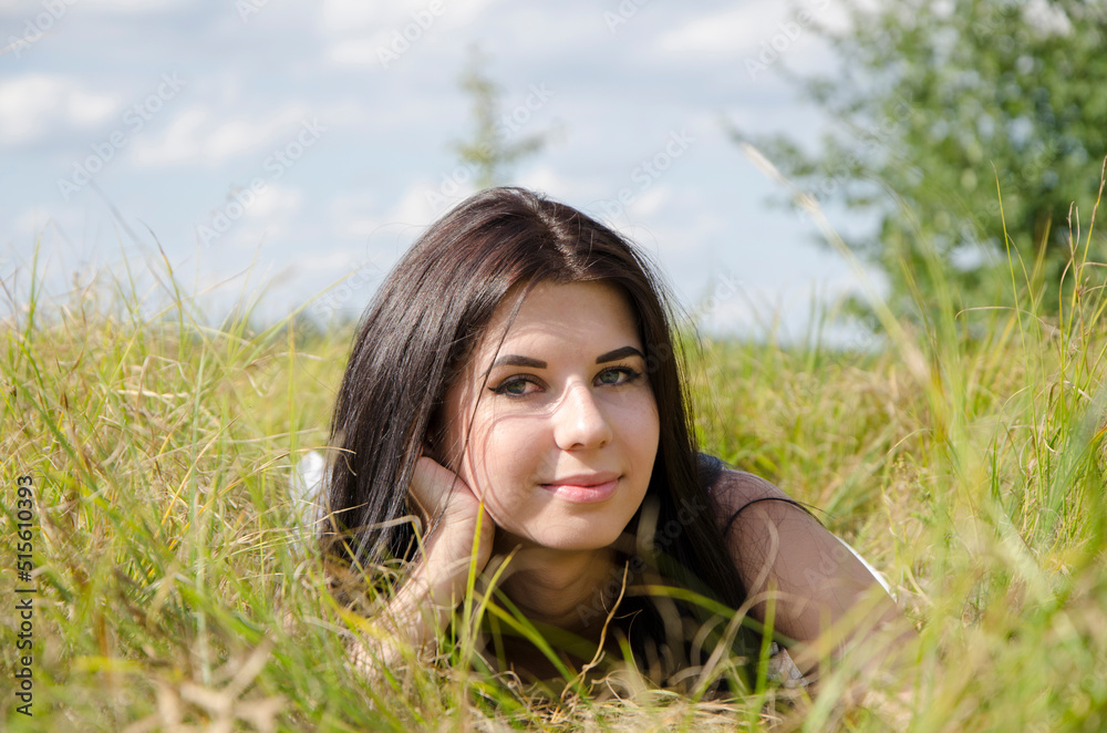 Portrait of young attractive woman. Young woman lying in the grass Portrait of young attractive woman. Young woman lying in the grass