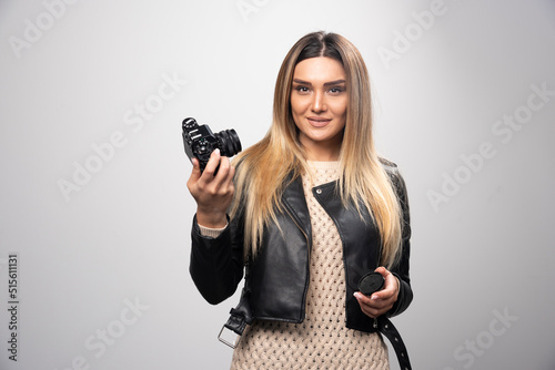 Blonde girl in black leather jacket taking her selfies with a camera