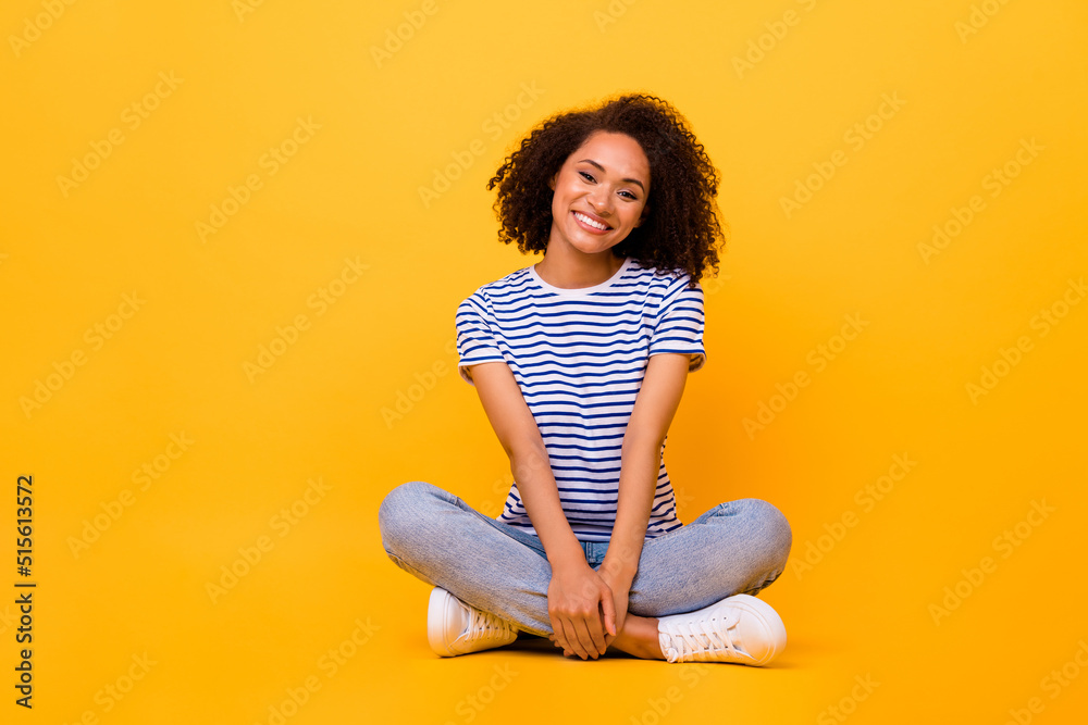 Full body portrait of adorable satisfied person sit floor have good mood isolated on yellow color background Full body portrait of adorable satisfied person sit floor have good mood isolated on yellow color background