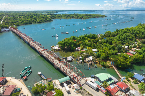 Anda, Pangasinan, Philippines - Aerial of the Anda Bridge connecting the island with the mainland and Bolinao. Crossing the Kakiputan Channel, which is dotted with several fish pens. photo