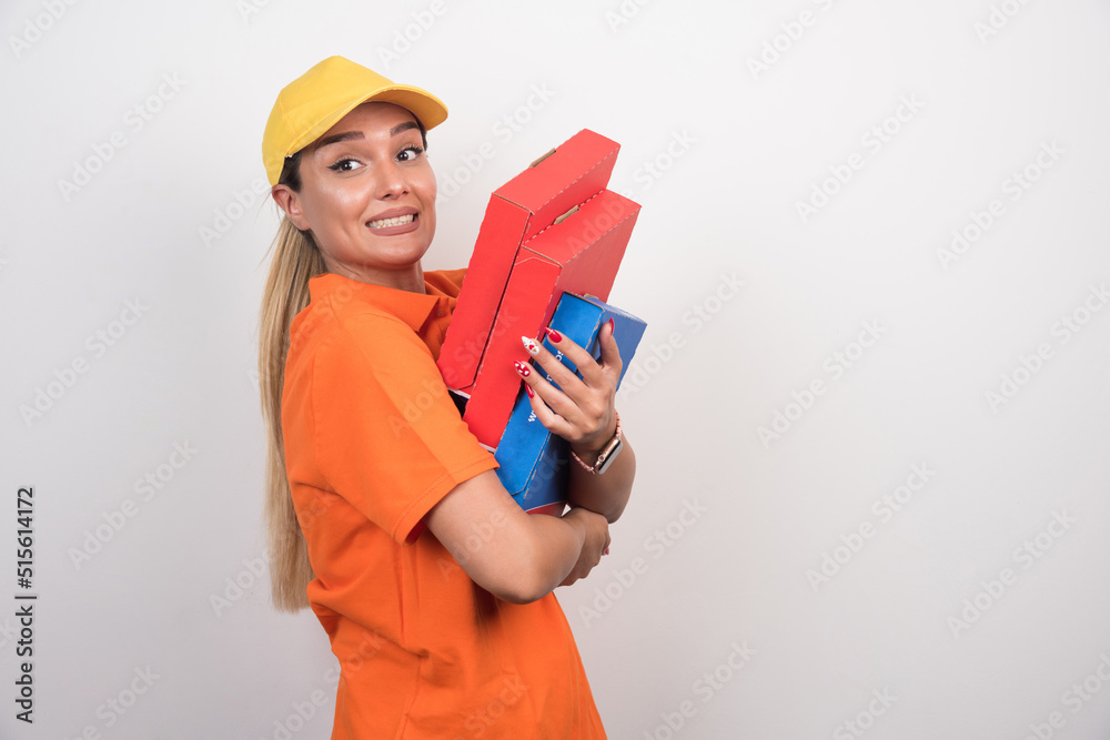 Pizza delivery woman holding pizza boxes looking at front on white background Pizza delivery woman holding pizza boxes looking at front on white background