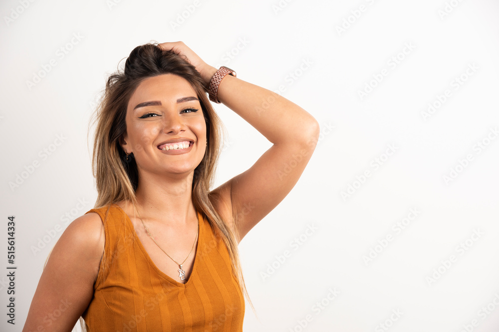 Positive woman touching her hair and posing on white background Positive woman touching her hair and posing on white background