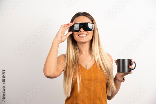 Young woman posing with glasses and black cup