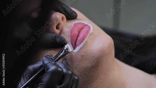 The girl circles her lips with a makeup brush.Makes a white contour.Close-up.