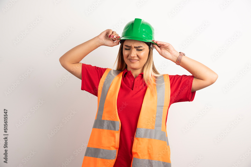 Beautiful worker woman wearing a green hardhat on white background Beautiful worker woman wearing a green hardhat on white background