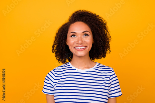 Portrait of excited satisfied person beaming smile look interested up empty space isolated on yellow color background © deagreez