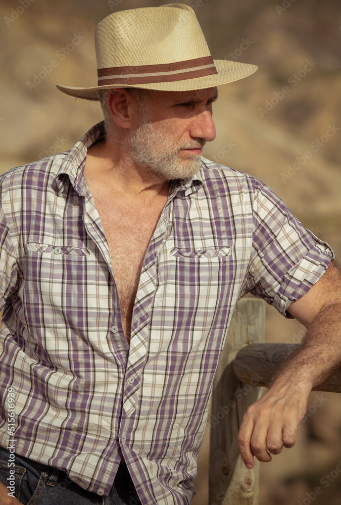 Portrait of adult man in sun hat and shirt in desert