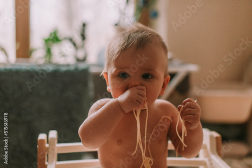 Cute baby eating spaghetti photo